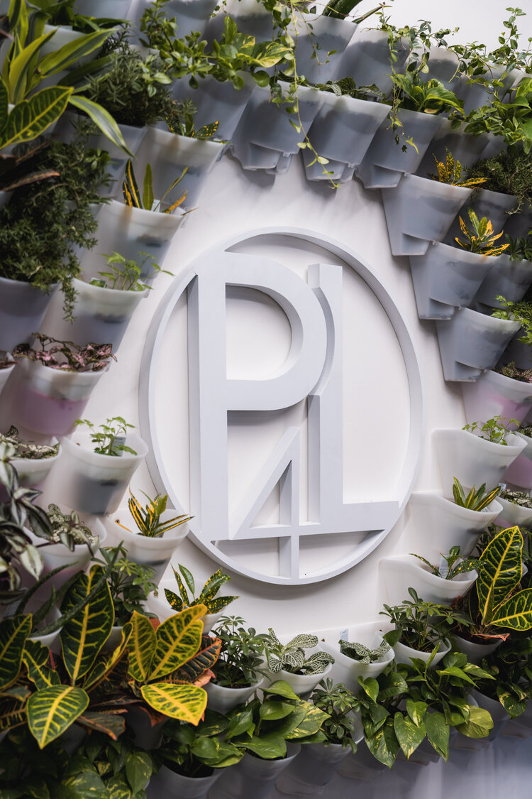 p4l logo on a wall with plants